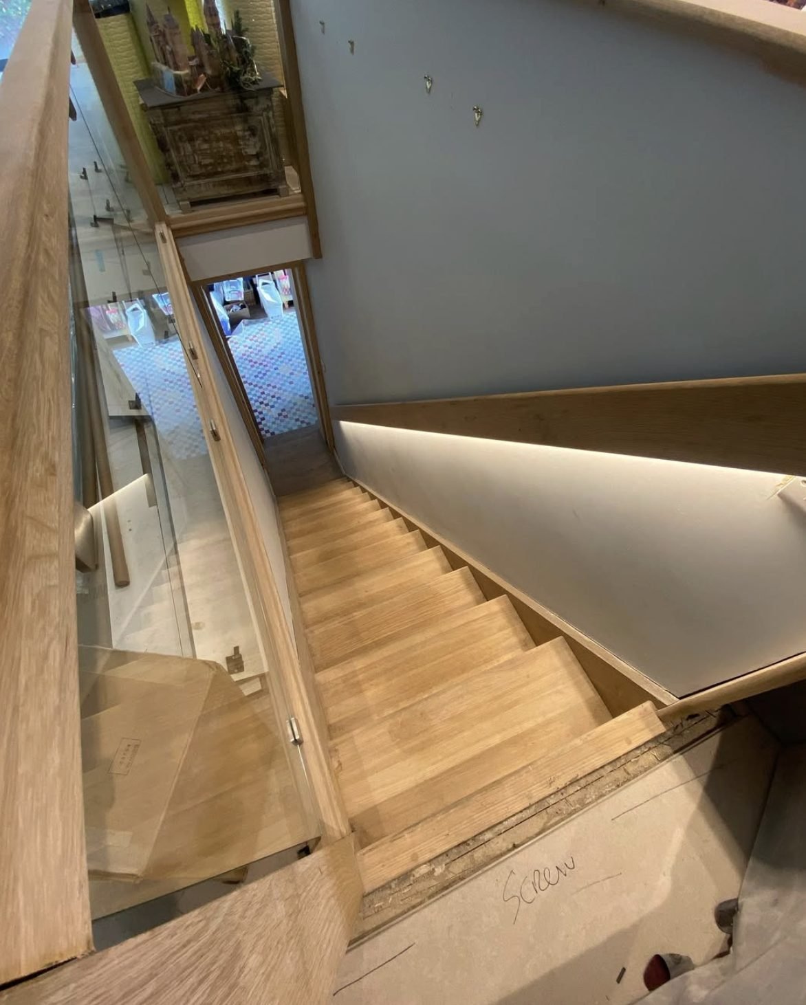 LED strip stair lighting on an oak and glass staircase